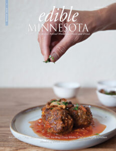 Edible Minnesota Magazine Winter 2024 Cover showing a plate of meatballs and someone sprinkling herbs over the top